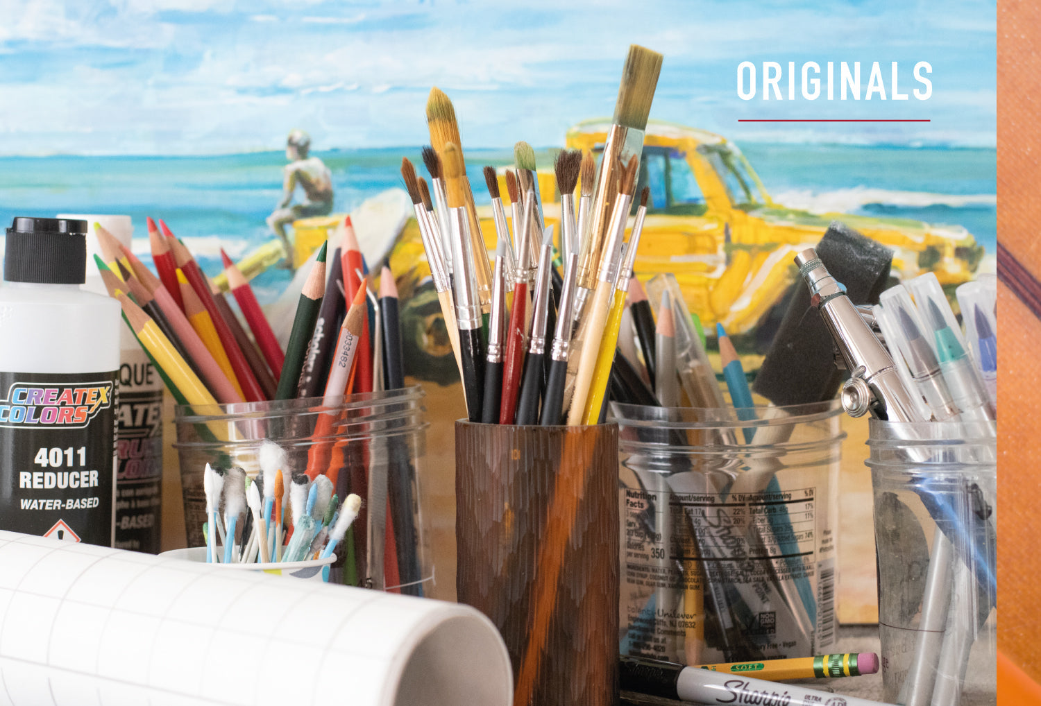 Original Paintings available. Photo of brushes, pens and pencils in art studio.