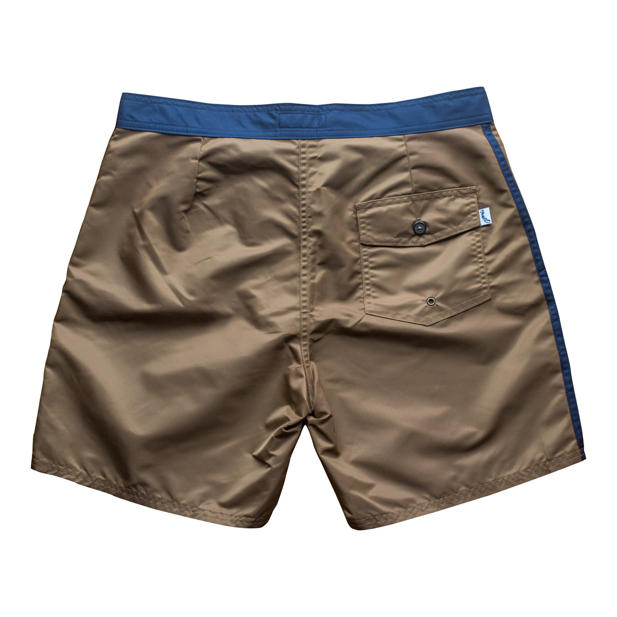 Back view of vintage style surf trunks in coyote brown with navy trim and navy stripes on side. Material is a durable satin nylon. Severson icon label on back pocket.