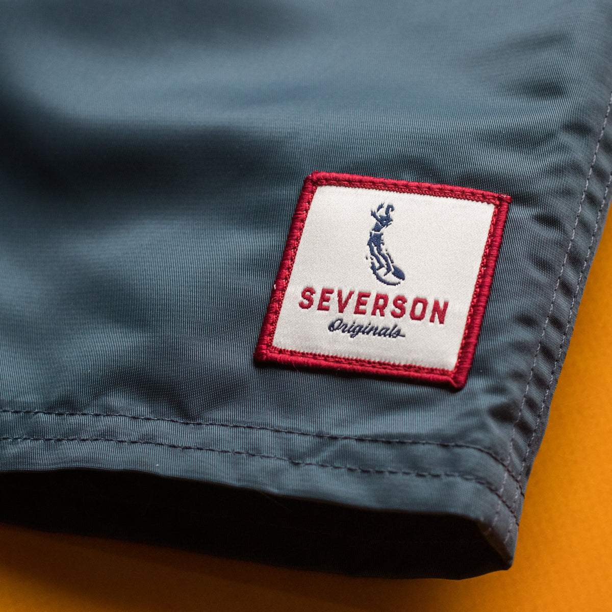 close up of severson embroidered patch on front left corner.