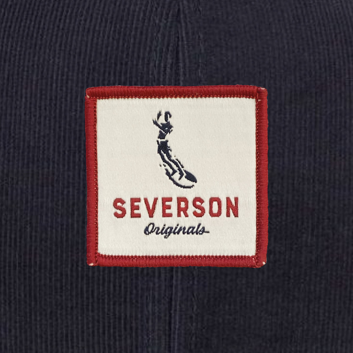 Close up view of Severson Originals logo in red, white and blue square patch.